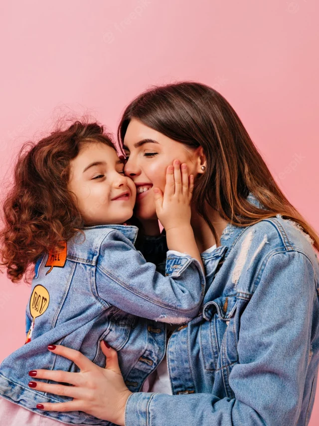 relaxed-preteen-girl-embracing-with-mother-winsome-young-mom-kissing-daughter-pink-background_197531-13683